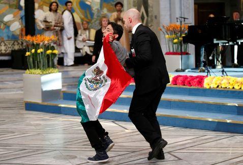 Mexicano interrumpe la entrega del Nobel a Malala; muestra una bandera manchada de rojo