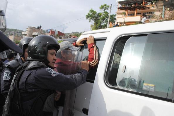 Policías se enfrentan con papás de Ayotzinapa por quitar propaganda electoral