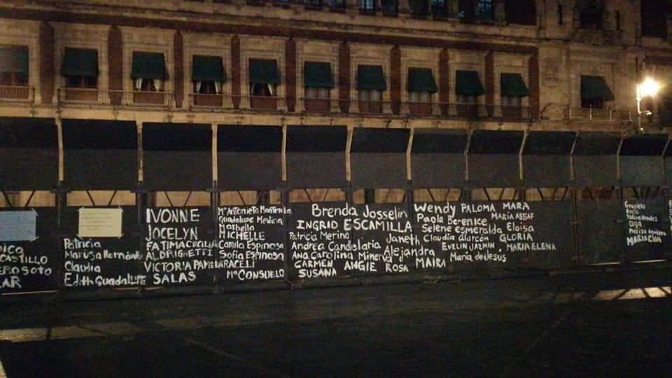 Mujeres escriben nombres de víctimas de feminicidio en muro que resguarda Palacio Nacional